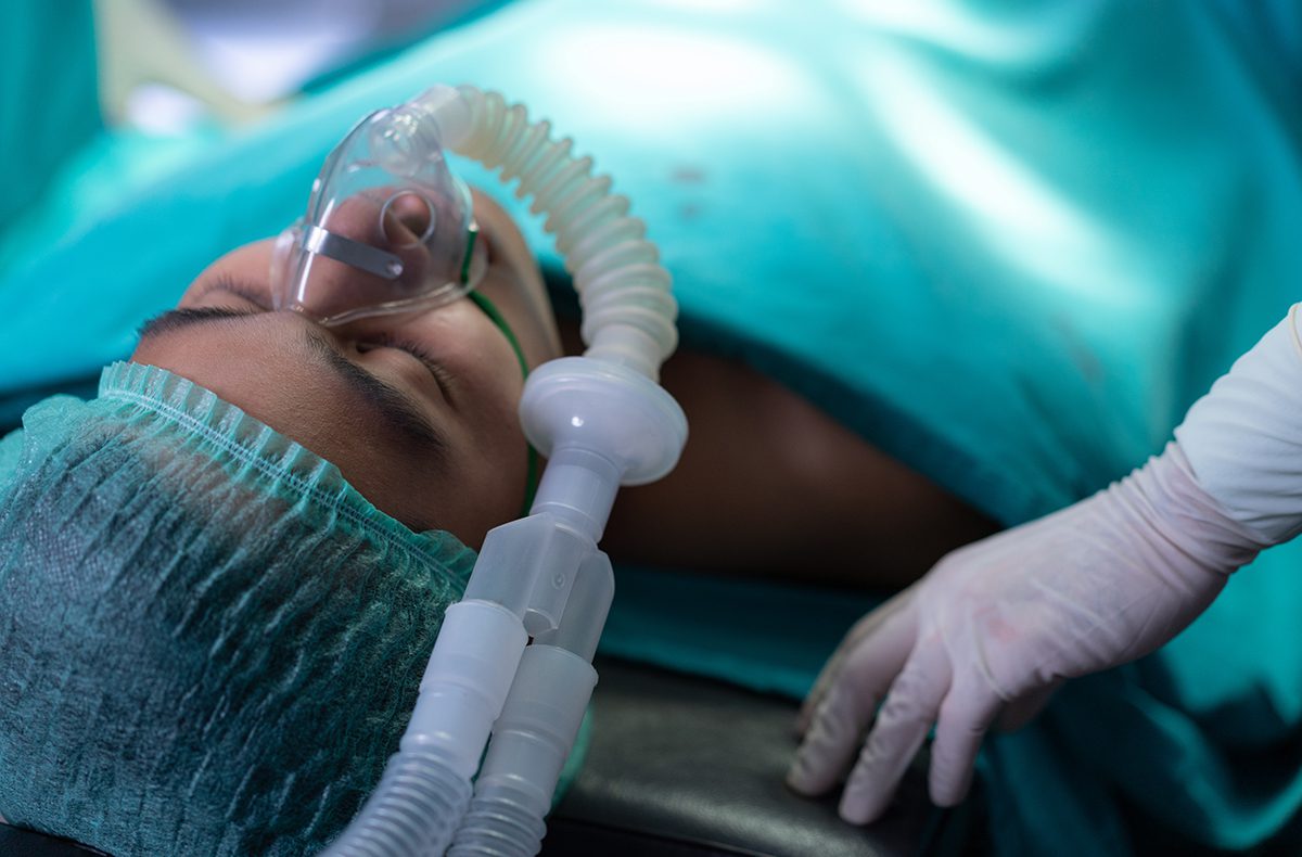 Patient wearing ventilator lying on the operating bed